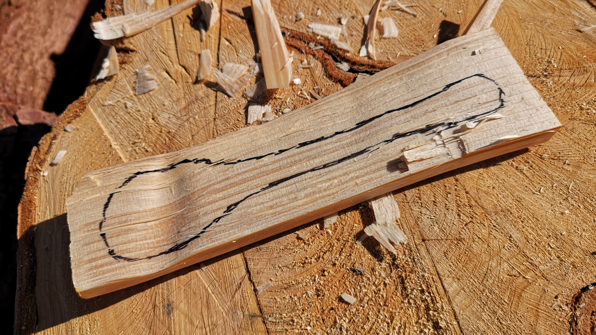 Un bloque de madera con una cuchara dibujada en él.