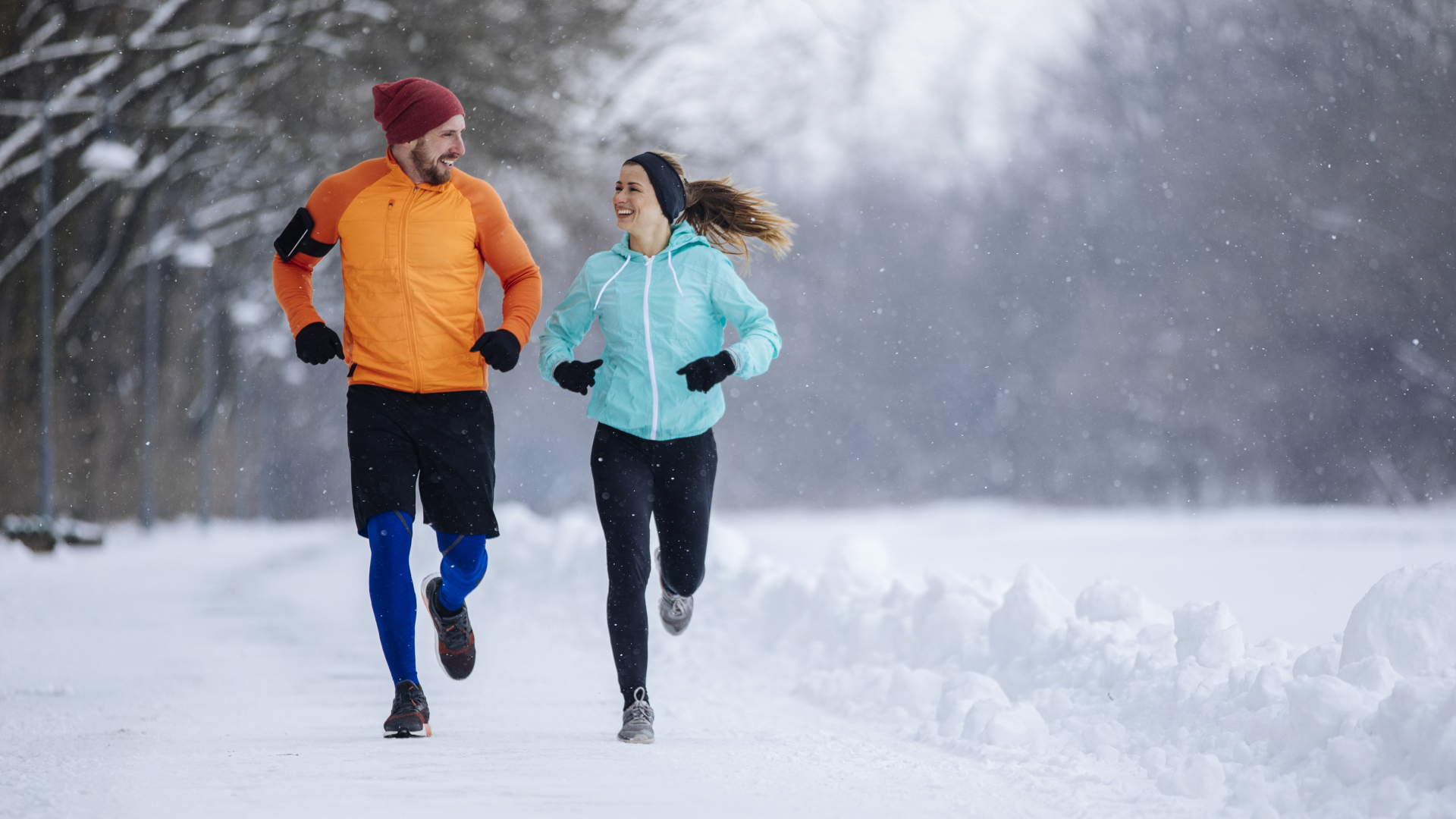 Un hombre y una mujer corren juntos en la nieve.