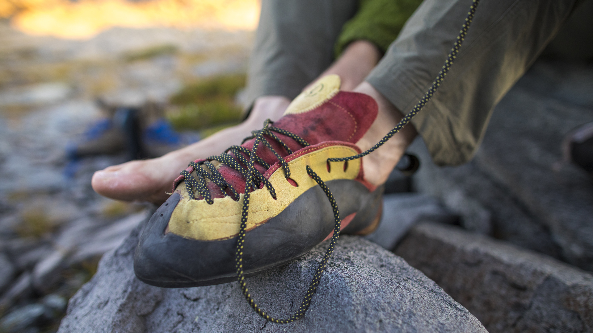 Un hombre atando los cordones de sus zapatos de escalada