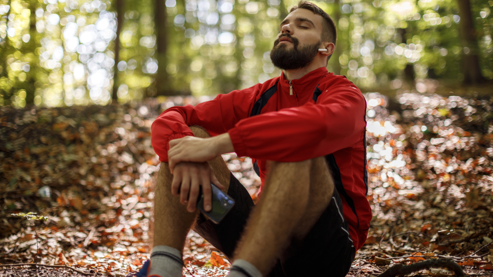 Un corredor se sienta y se relaja en un bosque.