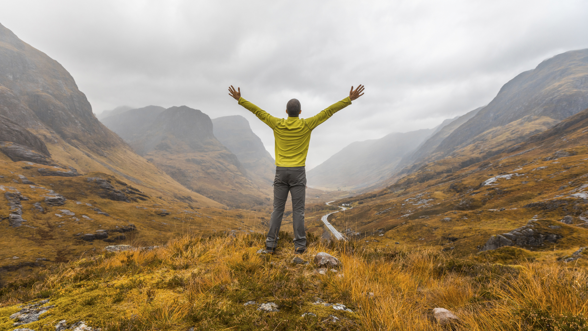 Un excursionista abre los brazos mientras mira a Glencoe en Escocia