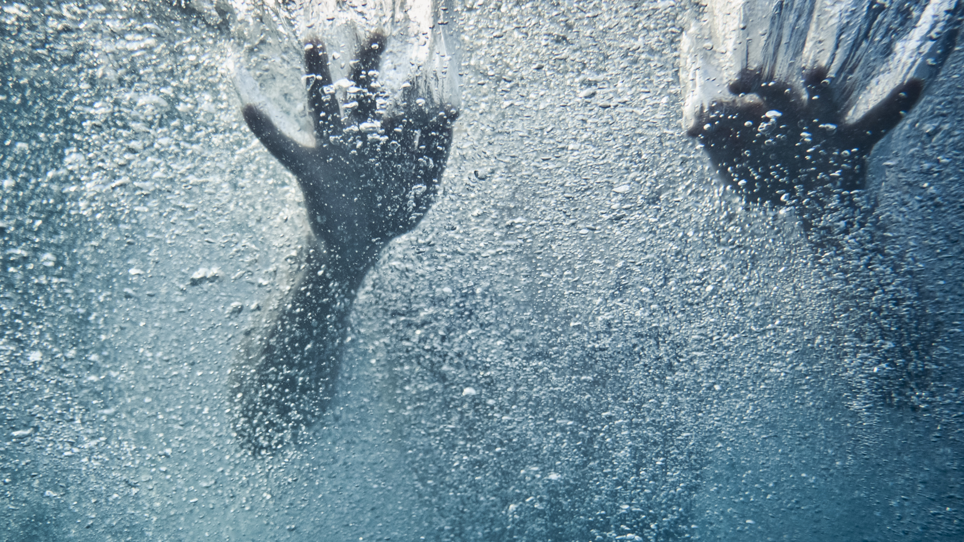 Las manos de un nadador bajo el agua