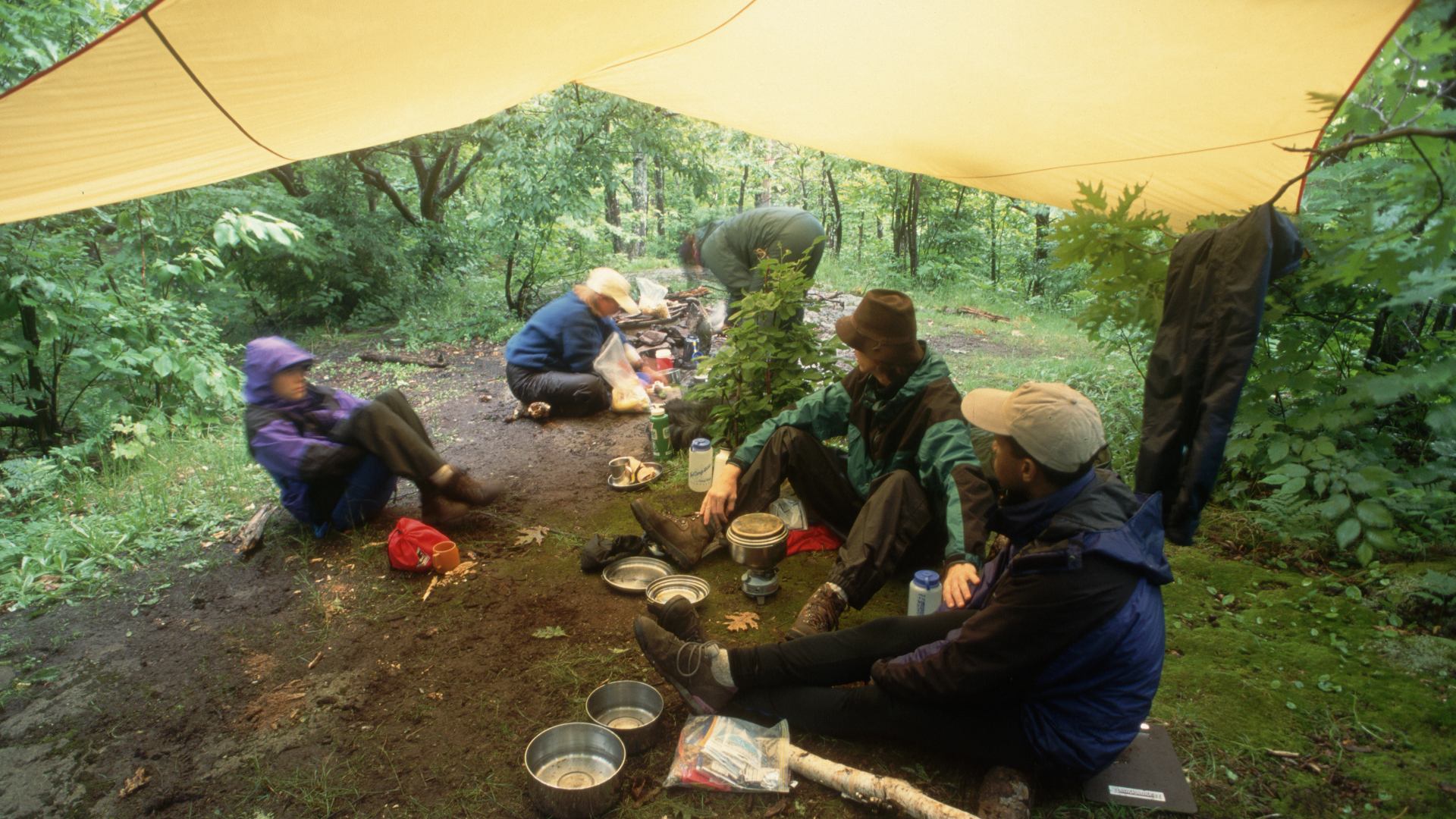 Cómo acampar bajo la lluvia: un grupo de campistas pasa el rato bajo una lona