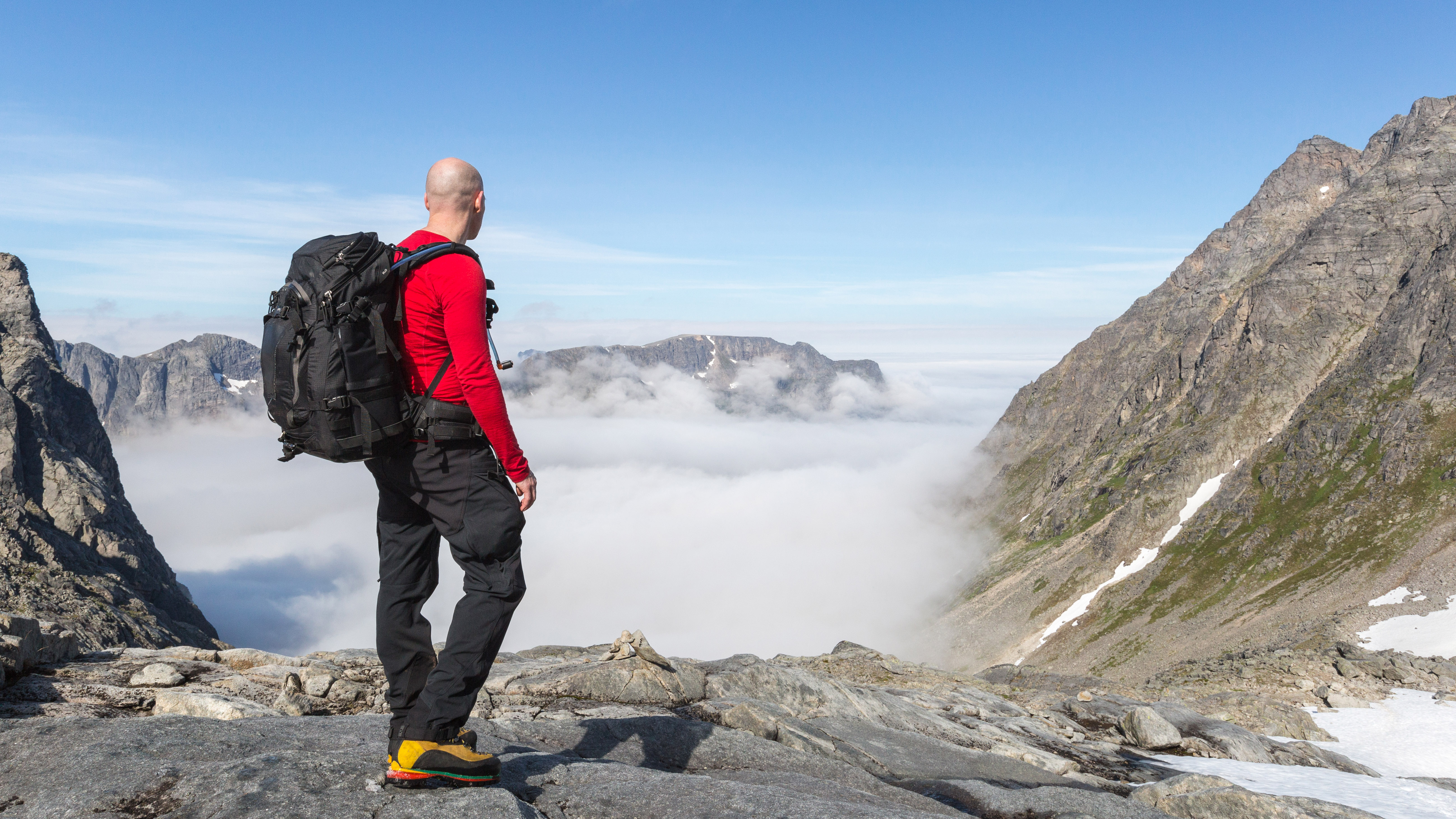 zapatos para caminar vs botas de montaña: hombre con botas de montaña en terreno rocoso