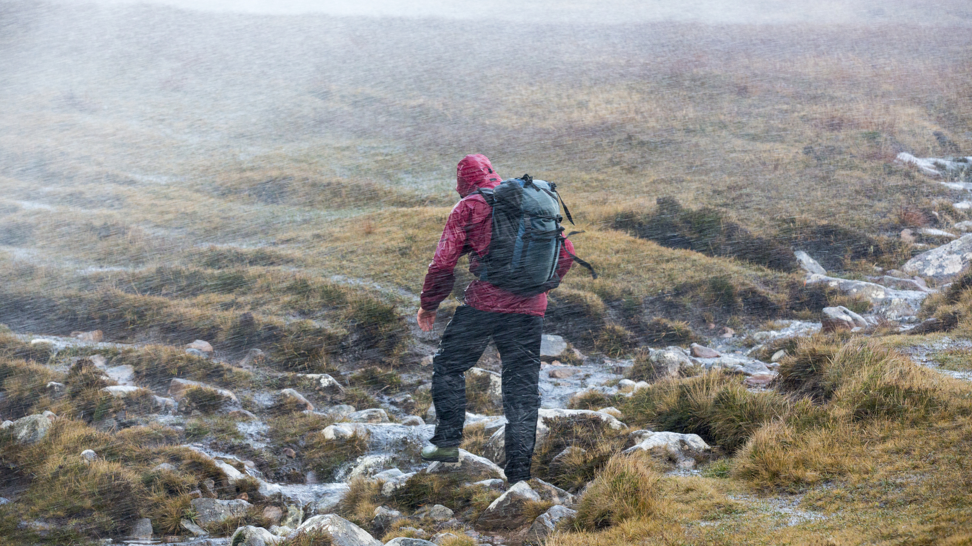 Un excursionista cruza un páramo en un clima ventoso de invierno