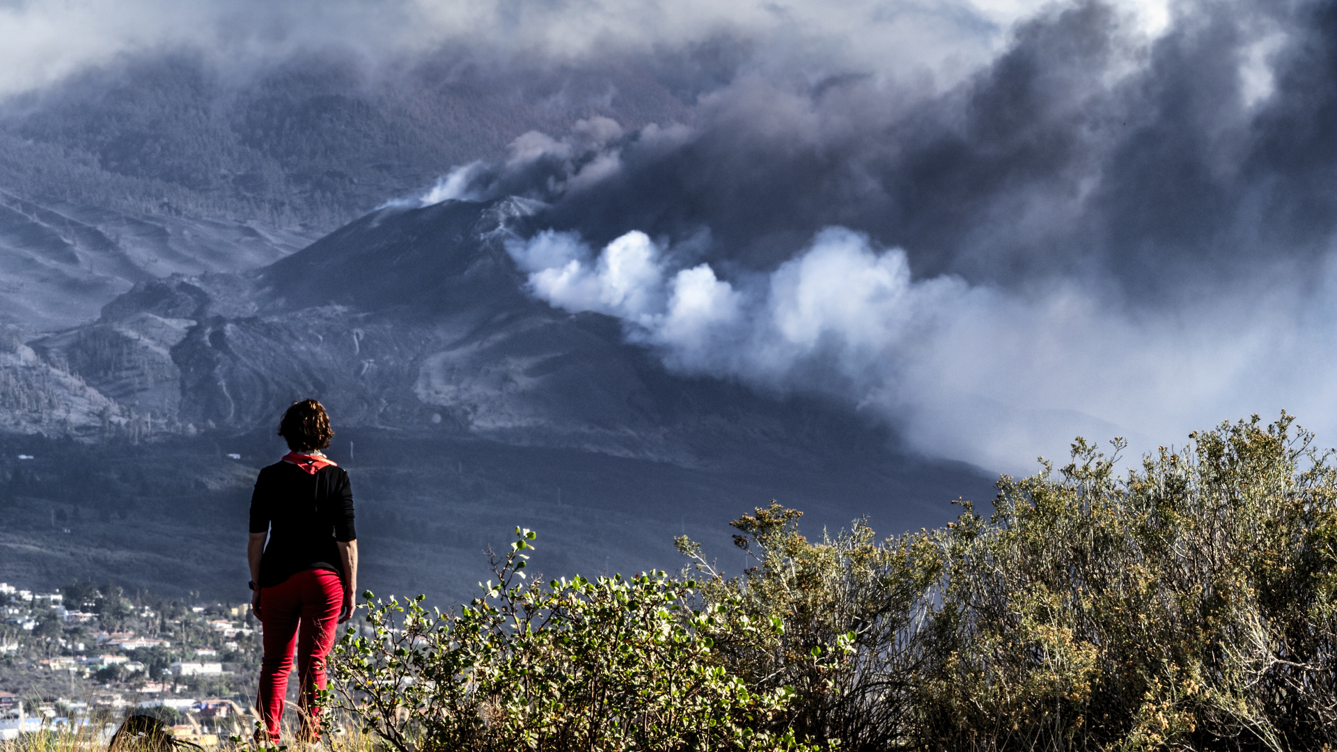 Un excursionista mira al otro lado de la colina una columna de humo.