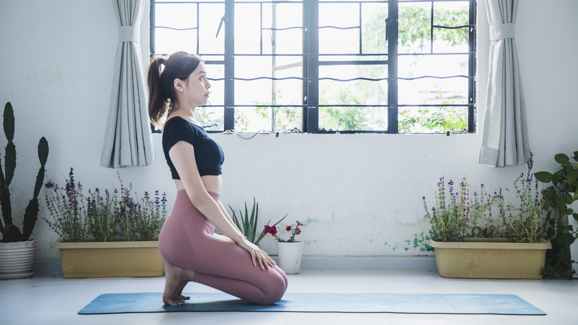 Una mujer se sienta sobre sus talones para estirar los pies en yoga