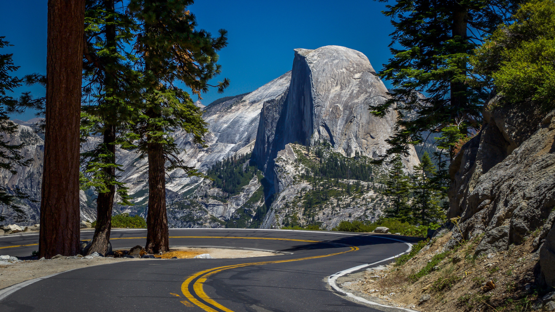 Un camino sinuoso en Yosemite que muestra Half Dome en la distancia