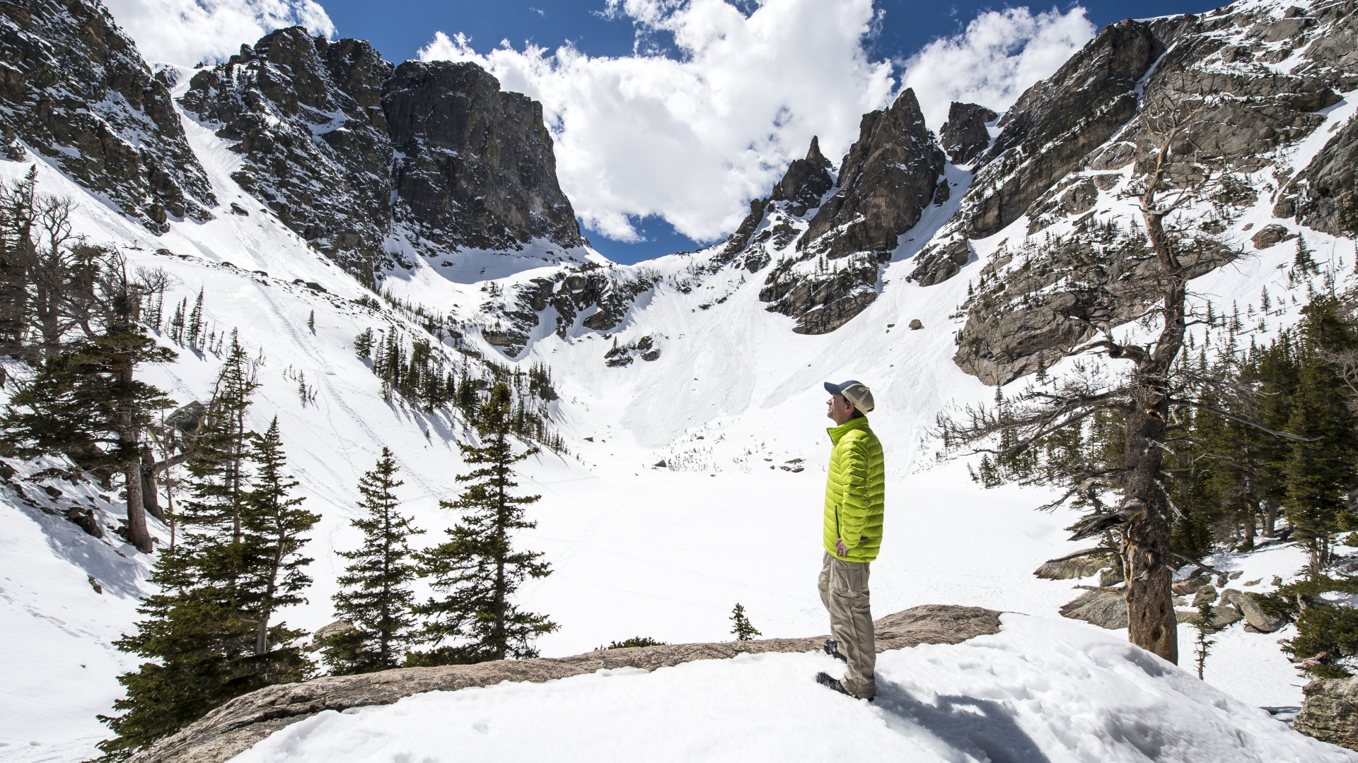 Un hombre caminando en un tazón de montaña cubierto de nieve