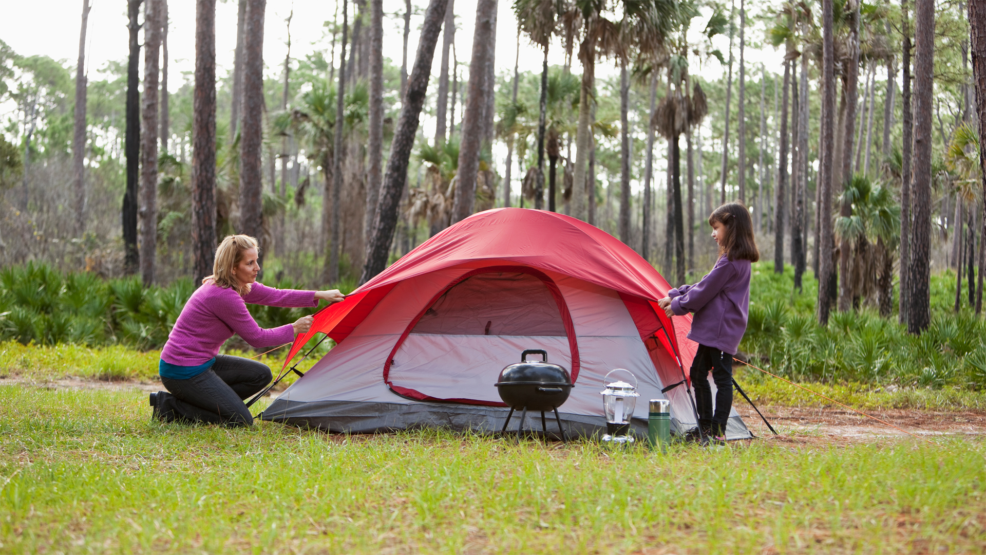cómo montar una tienda de campaña: pareja montando un campamento salvaje