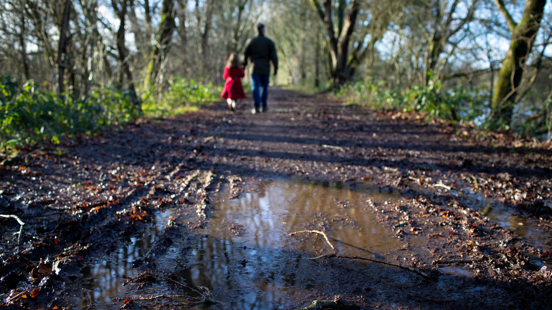 Dos personas caminando por un sendero fangoso